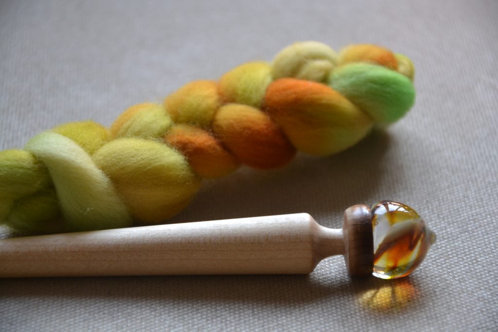 Zoom sur la pointe en verre du fuseau et la tresse de fibres colorées